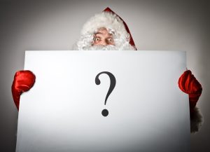 Santa Claus holding a large white board with a question mark