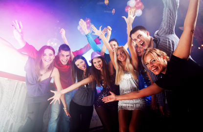 Group of friends celebrating at a lively party with colourful lights