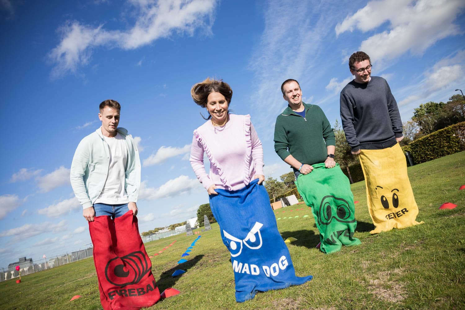 Adults taking part in outdoor sack race team building activity