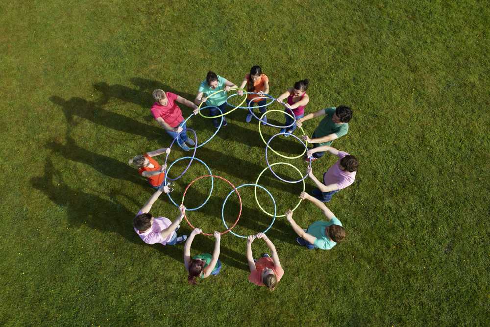 People holding hula hoops in circle