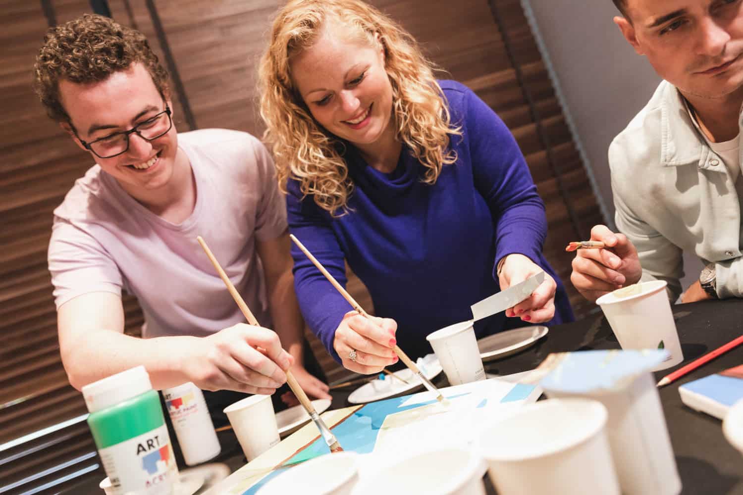 Team painting activity during indoor corporate team building workshop