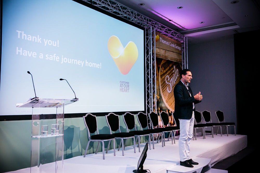 Corporate speaker presenting on stage at conference event