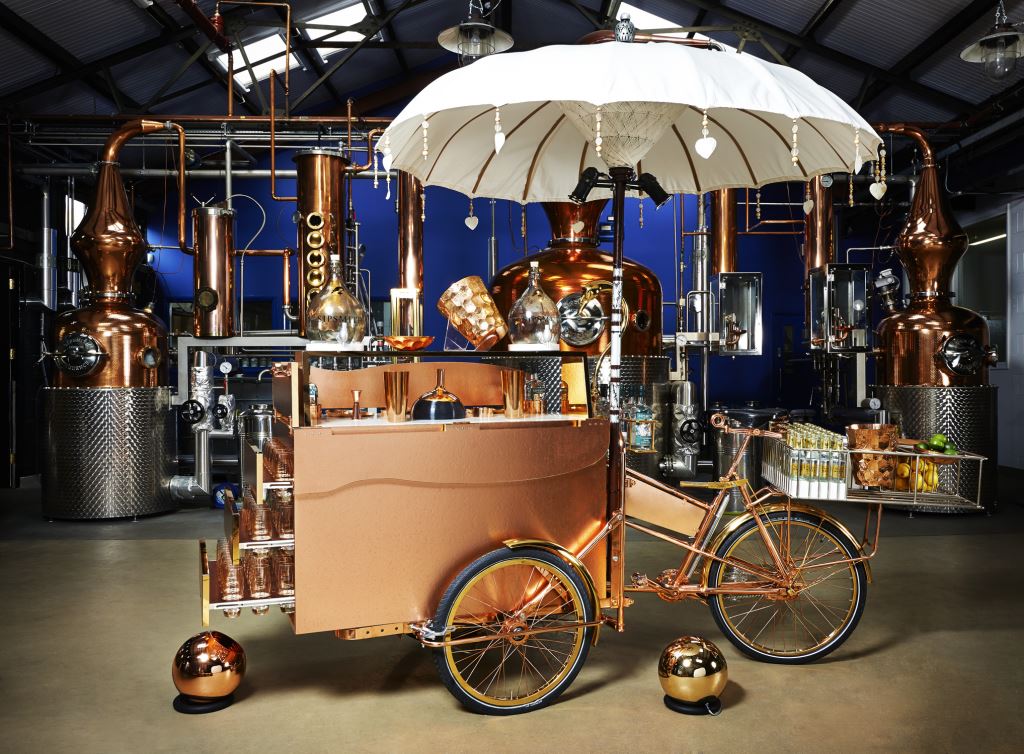 Copper cocktail tricycle cart inside distillery venue