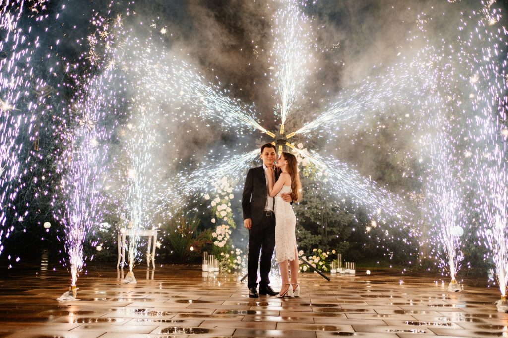 Couple under wedding fireworks display with sparklers