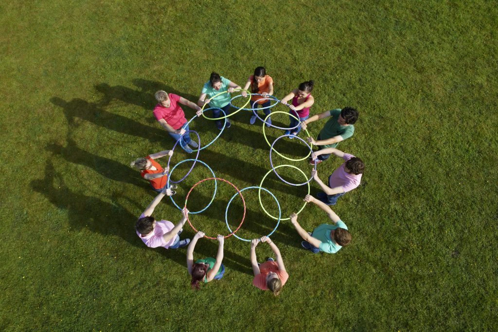Group taking part in a hula hoop team building activity outdoors in Hampshire