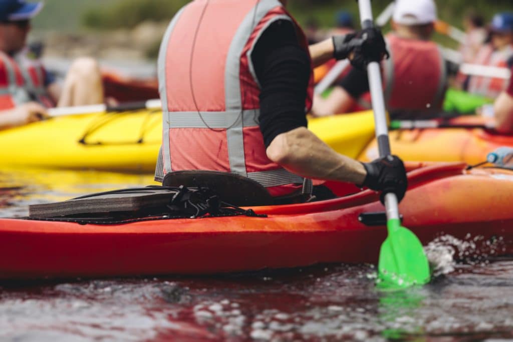 Group taking part in a kayaking team building activity on the water